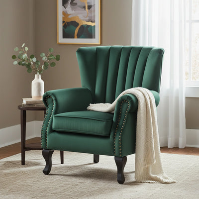 Green armchair with a white blanket in a room with a side table and artwork.